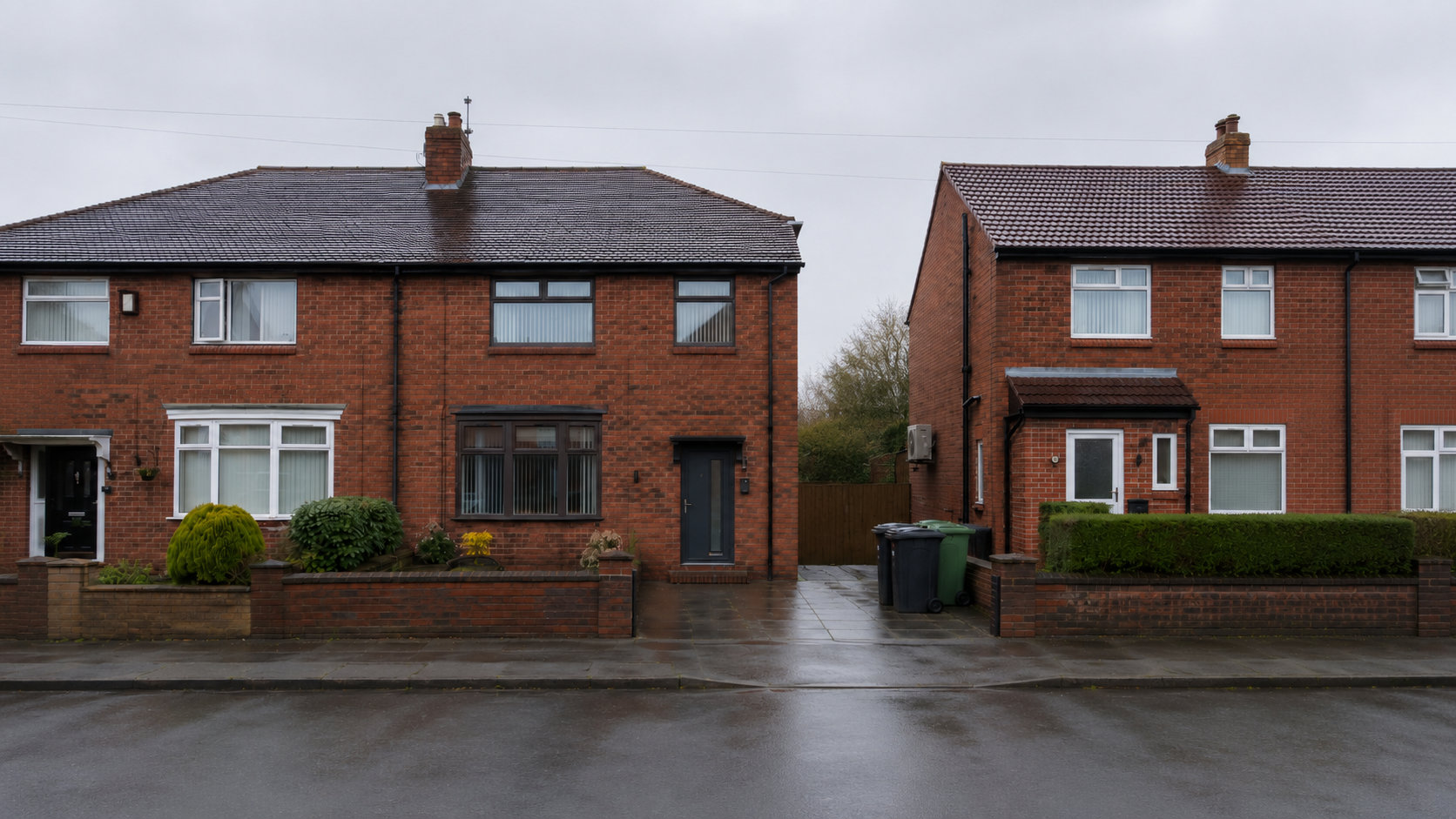North West UK semi-detached houses on a wet street with a wall-mounted outdoor air conditioning unit visible on the neighbouring property